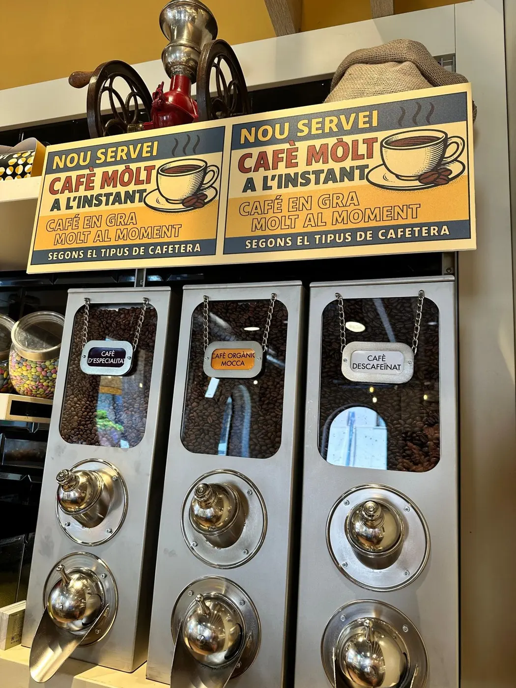Dispensadors de cafè en gra amb el cartell de cafè molt a l'instant
